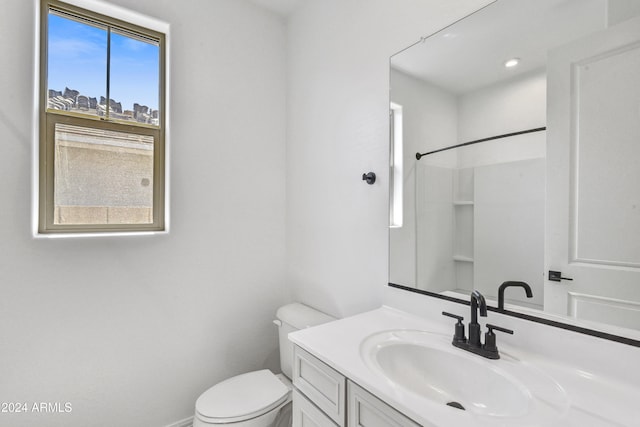 bathroom featuring toilet, walk in shower, and vanity