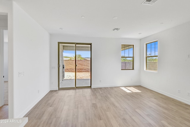 spare room with light hardwood / wood-style flooring and a wealth of natural light