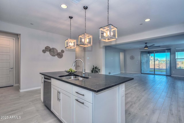 kitchen featuring sink, hanging light fixtures, a center island with sink, dishwasher, and white cabinets