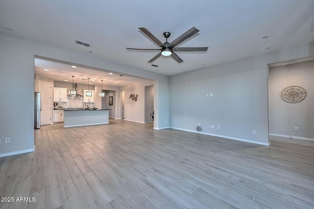 unfurnished living room with ceiling fan and light wood-type flooring