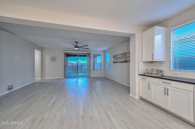 unfurnished living room with ceiling fan and light wood-type flooring