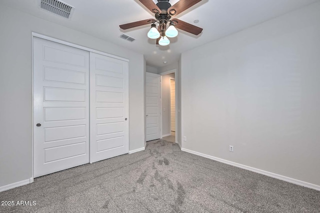 unfurnished bedroom with carpet floors, ceiling fan, and a closet