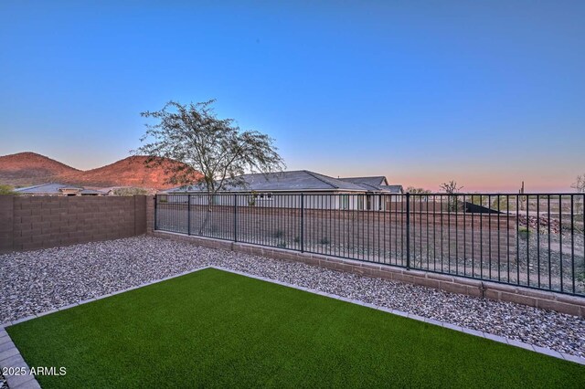 yard at dusk featuring a mountain view