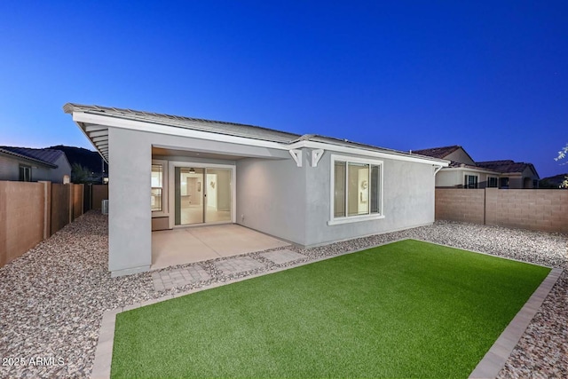 rear view of house with a patio and a lawn