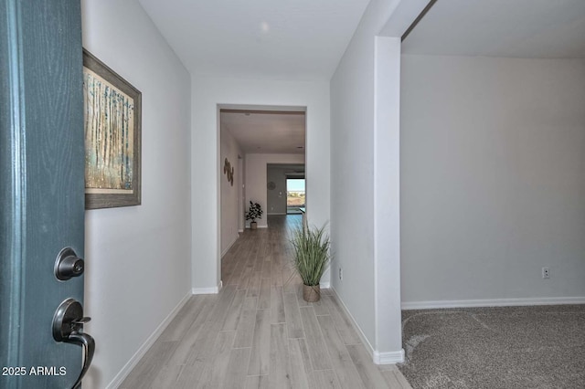 corridor with light hardwood / wood-style floors