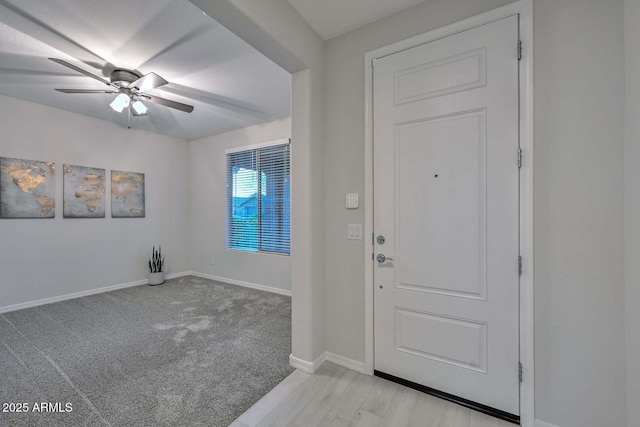 carpeted foyer with ceiling fan