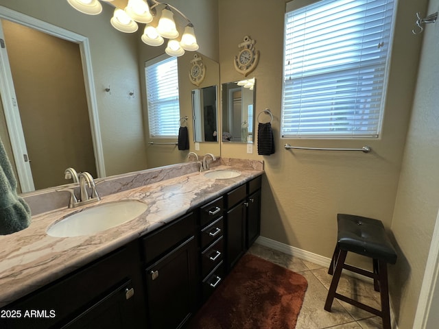 full bathroom with a chandelier, double vanity, a sink, and tile patterned floors