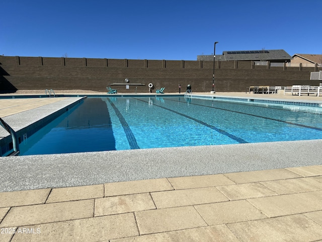 community pool with fence and a patio