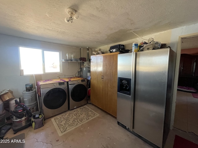 clothes washing area featuring washing machine and clothes dryer, water heater, and a textured ceiling