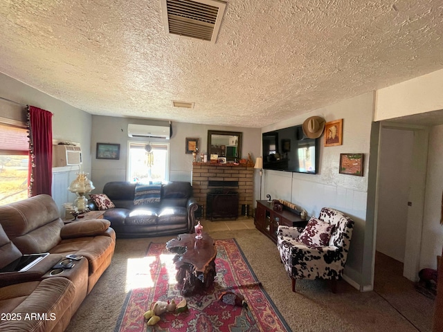 living room with an AC wall unit, carpet flooring, a textured ceiling, and a brick fireplace