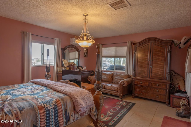 bedroom featuring light tile patterned flooring and a textured ceiling