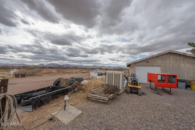 view of yard featuring an outbuilding, a garage, and a mountain view