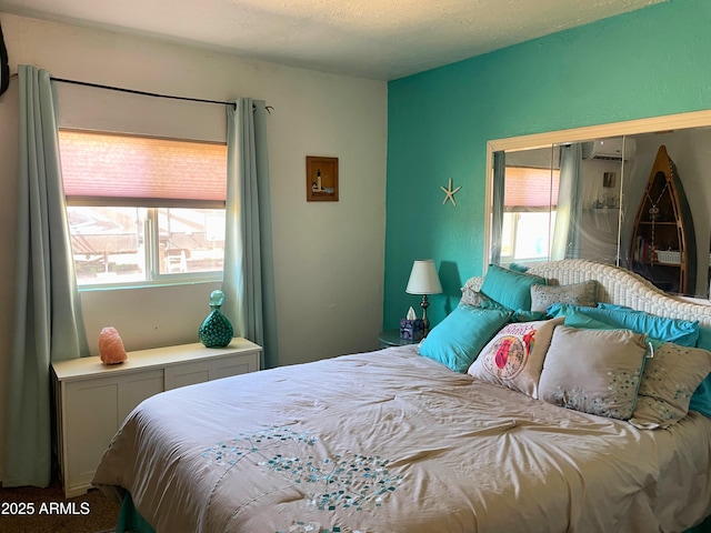 bedroom featuring a wall mounted air conditioner and multiple windows