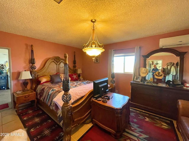 bedroom with a textured ceiling and a wall unit AC