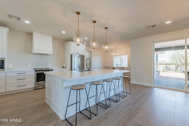 3939 S Veronica Ln, Gold Canyon, AZ 85118 - kitchen with a sink, range hood, a breakfast bar, stainless steel appliances, and visible vents