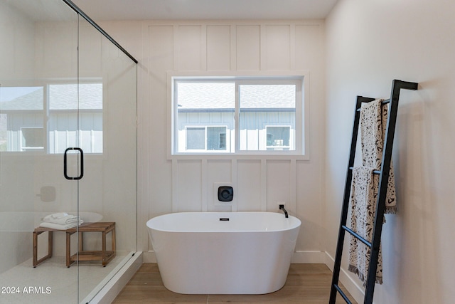 3939 S Veronica Ln, Gold Canyon, AZ 85118 - bathroom featuring a shower stall, wood finished floors, a freestanding tub, and a decorative wall