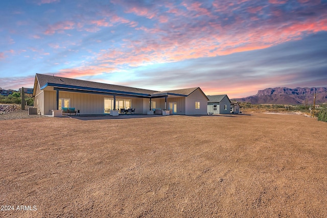 3939 S Veronica Ln, Gold Canyon, AZ 85118 - back of house at dusk featuring a mountain view, central AC, and a patio area