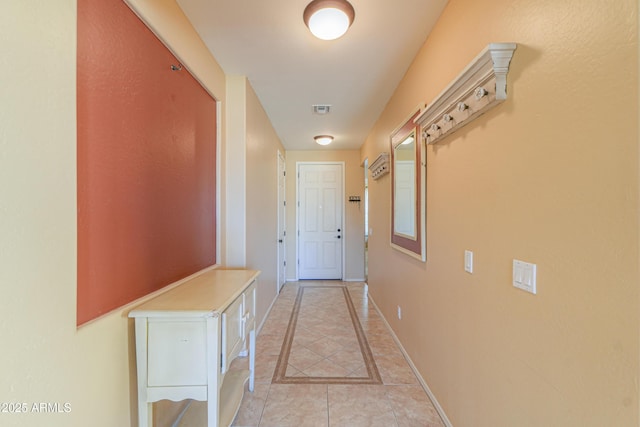 doorway to outside featuring visible vents, baseboards, and light tile patterned flooring