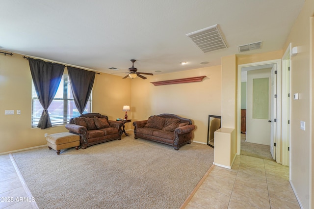 living area featuring light tile patterned flooring, visible vents, and light colored carpet