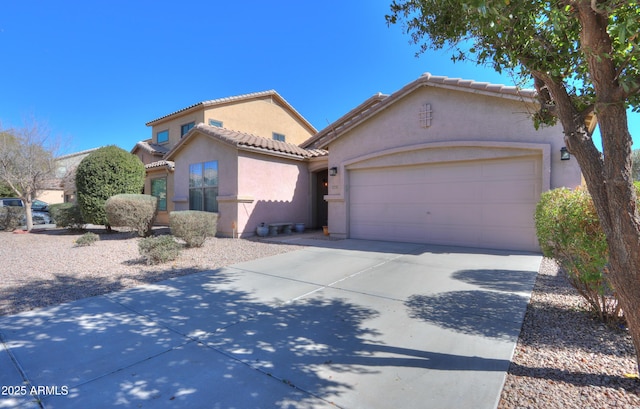 mediterranean / spanish-style home with a garage, concrete driveway, a tile roof, and stucco siding