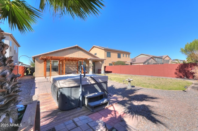 view of front of home with a patio area, a fenced backyard, a hot tub, and stucco siding