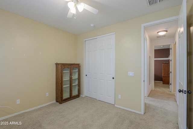 unfurnished bedroom with light carpet, a closet, visible vents, and baseboards