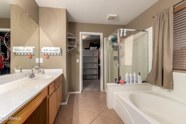 bathroom featuring a bath, visible vents, tile patterned flooring, a stall shower, and vanity