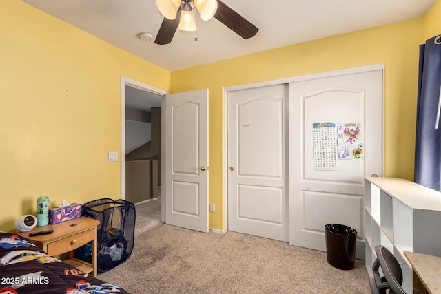 bedroom featuring a ceiling fan, light colored carpet, and a closet