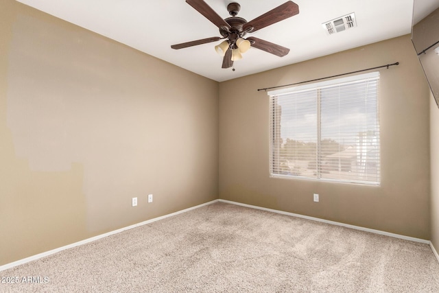 carpeted spare room featuring ceiling fan, visible vents, and baseboards
