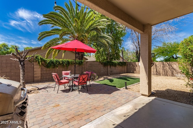 view of patio / terrace featuring a fenced backyard, outdoor dining space, and a grill