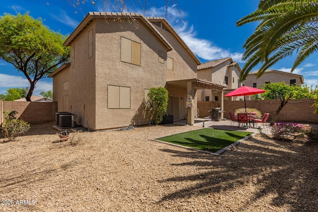 back of house featuring a patio, a fenced backyard, stucco siding, and central AC unit