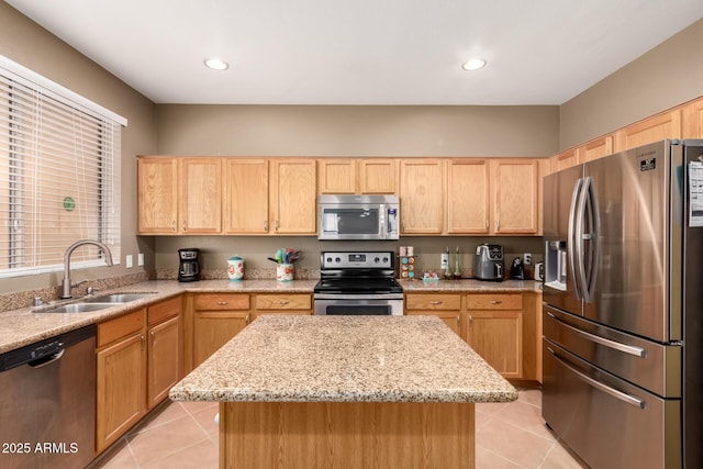 kitchen with a sink, light tile patterned floors, light brown cabinets, and stainless steel appliances