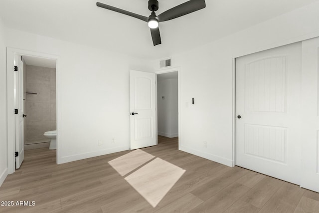 unfurnished bedroom with connected bathroom, light hardwood / wood-style floors, a closet, and ceiling fan