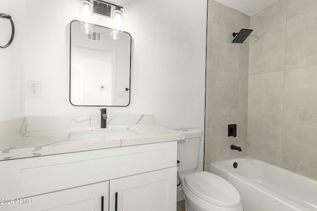 full bathroom featuring vanity, tiled shower / bath combo, and toilet