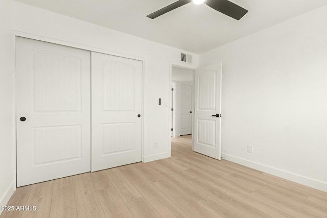 unfurnished bedroom with ceiling fan, light wood-type flooring, and a closet