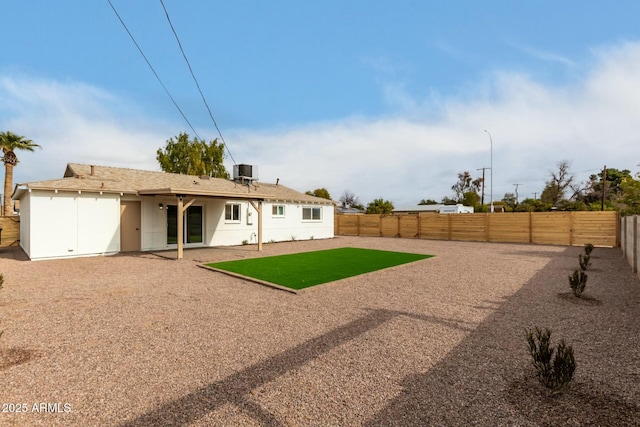 rear view of house with central AC unit, a patio area, and a lawn