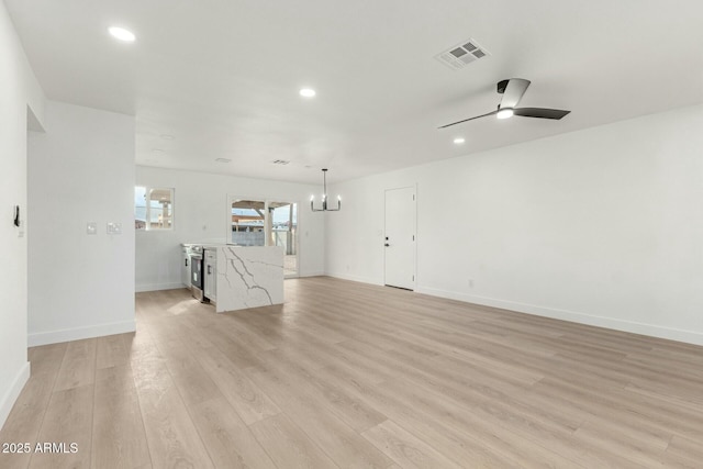 unfurnished living room with ceiling fan with notable chandelier and light hardwood / wood-style flooring