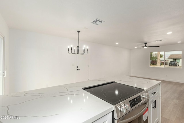 kitchen featuring stainless steel electric range, light hardwood / wood-style flooring, light stone countertops, and white cabinets