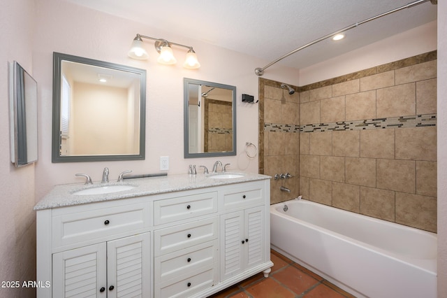 bathroom with vanity, tile patterned flooring, and tiled shower / bath