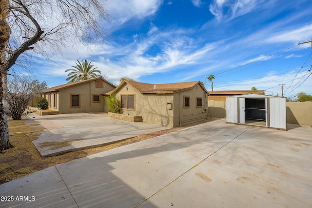 view of front of house with a patio area and a storage unit