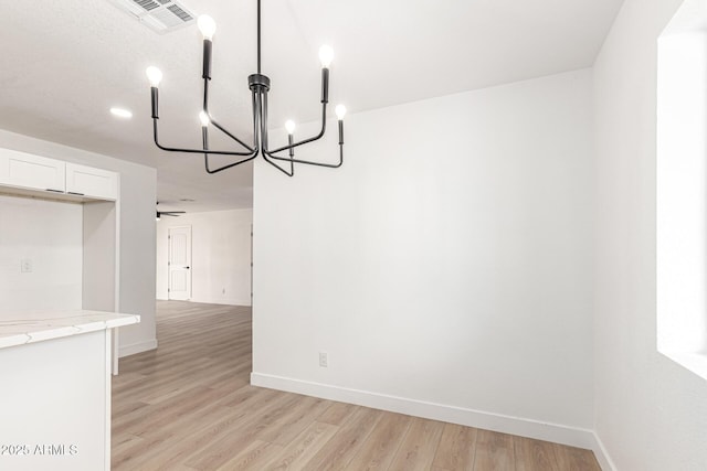 524 S Pioneer, Mesa, AZ 85204 - unfurnished dining area with a chandelier, light wood-style flooring, and baseboards