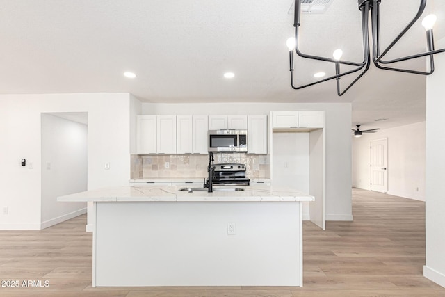 524 S Pioneer, Mesa, AZ 85204 - kitchen with stainless steel appliances, baseboards, a center island with sink, backsplash, and recessed lighting