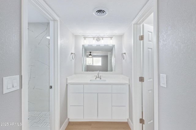 bathroom featuring hardwood / wood-style flooring, a shower, and vanity