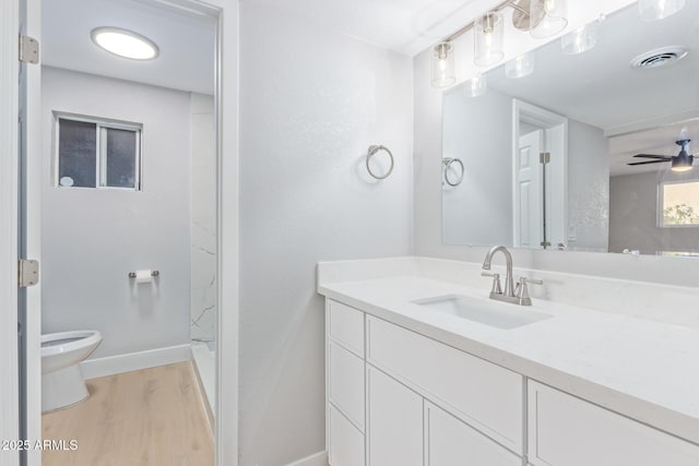 bathroom featuring walk in shower, toilet, vanity, hardwood / wood-style flooring, and ceiling fan