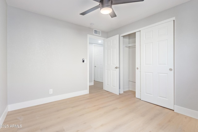 unfurnished bedroom with ceiling fan, a closet, and light wood-type flooring