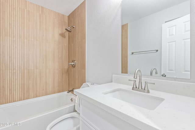 full bathroom featuring tiled shower / bath combo, vanity, and toilet