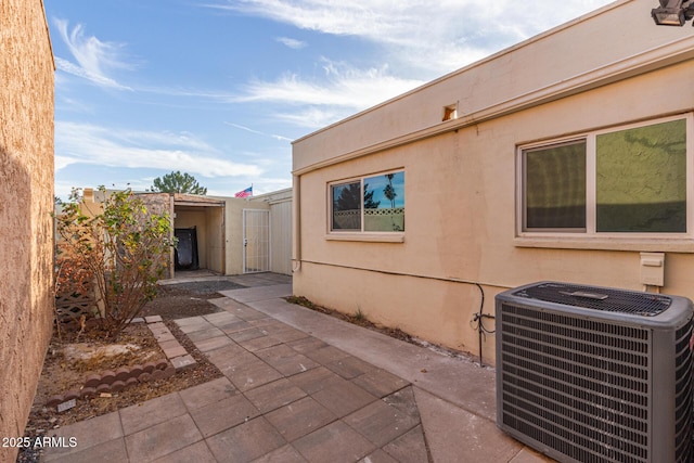 view of side of property with central AC unit and a patio area