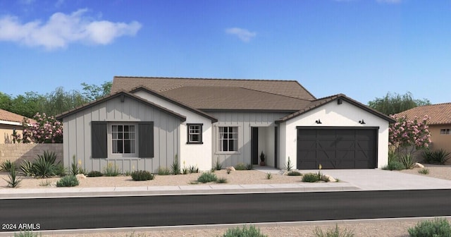 view of front facade featuring an attached garage, a tile roof, board and batten siding, and concrete driveway