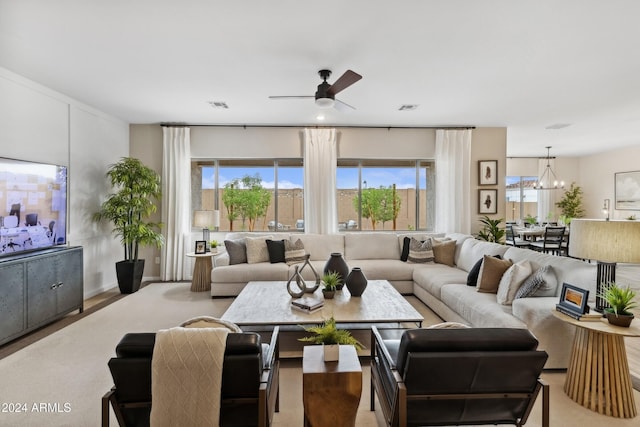 living room with ceiling fan with notable chandelier