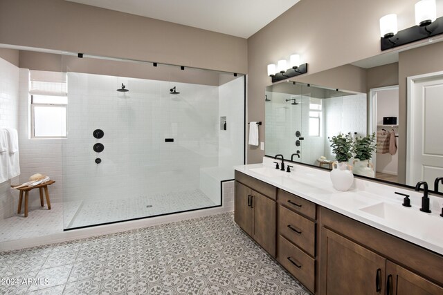 bathroom with double vanity, walk in shower, tile patterned flooring, and a sink